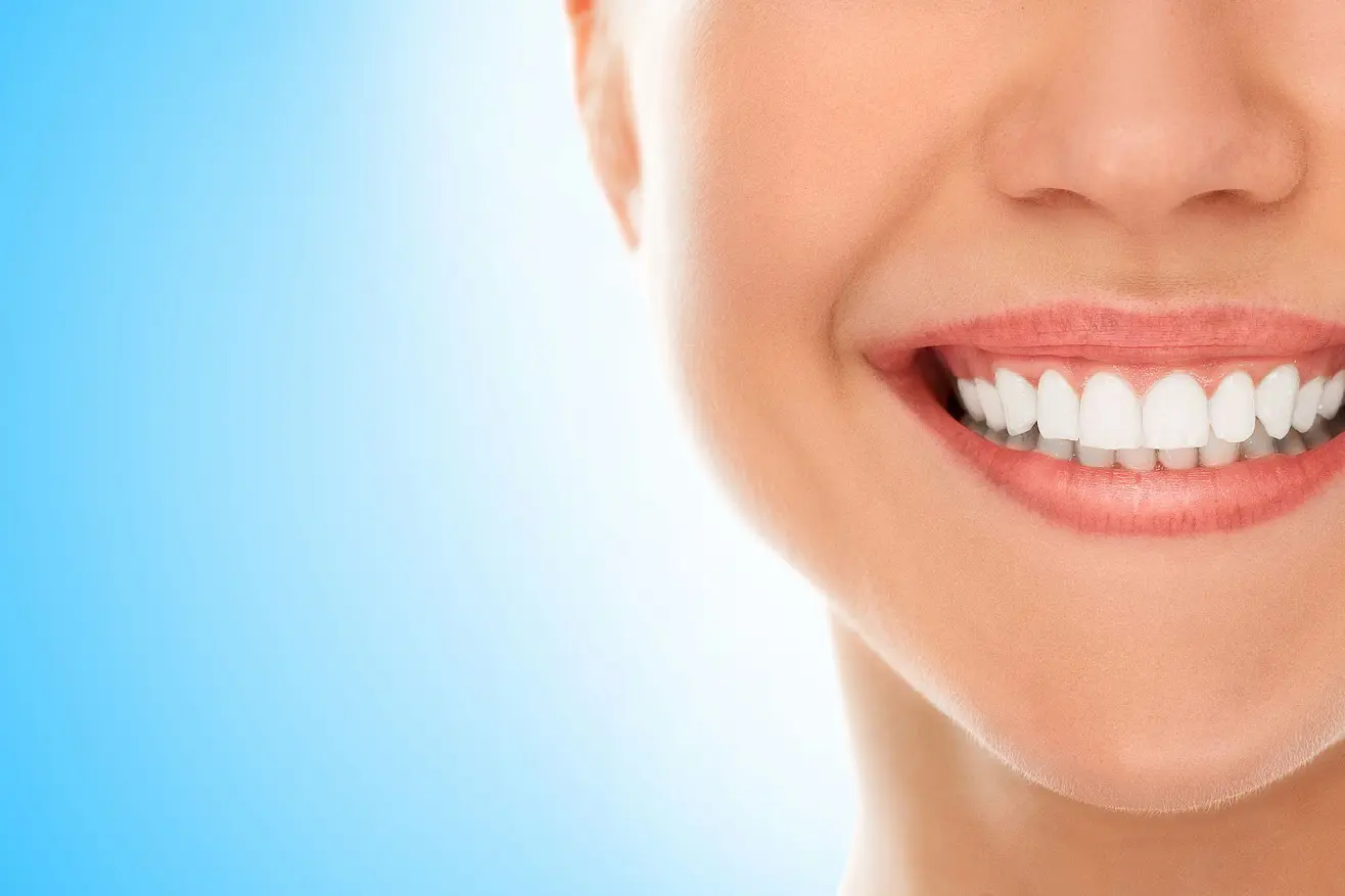 A close-up features a wide smile with clean, white teeth and Metal Braces, captured at Stellar Orthodontics in San Marcos CA, set against a light blue background.