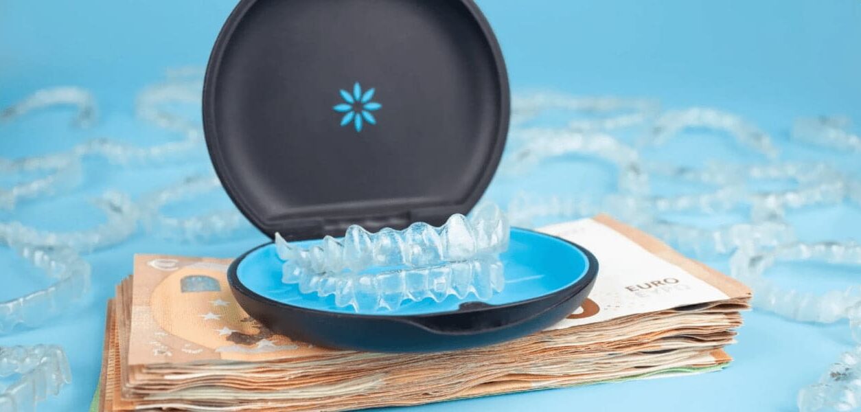 Invisalign with a black case rest on euro bills, showcasing affordable Invisalign cost at Stellar Orthodontics in San Marcos, CA.